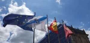 Bandera de EU, Galicia, España y Santiago de Compostela ondeando al viento en la Plaza del Obradoiro